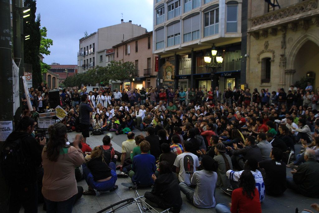 Assemblea de l'acampada del 15M al Raval de Montserrat, Terrassa, de nit i plena de gent asseguda a terra